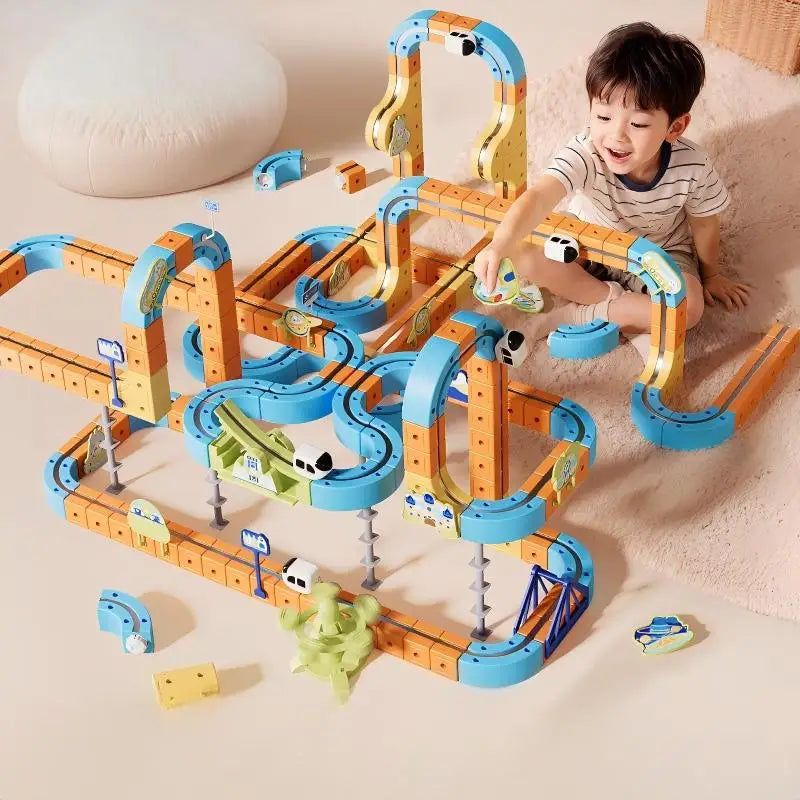Child building a large magnetic monorail layout on the floor